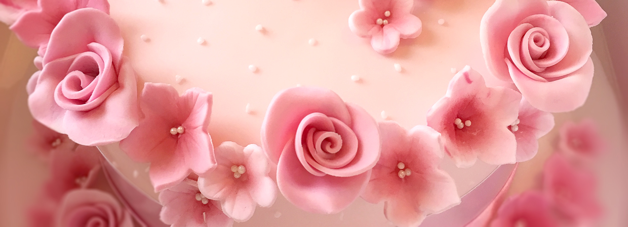 Close up of pink flower roses decorating cake